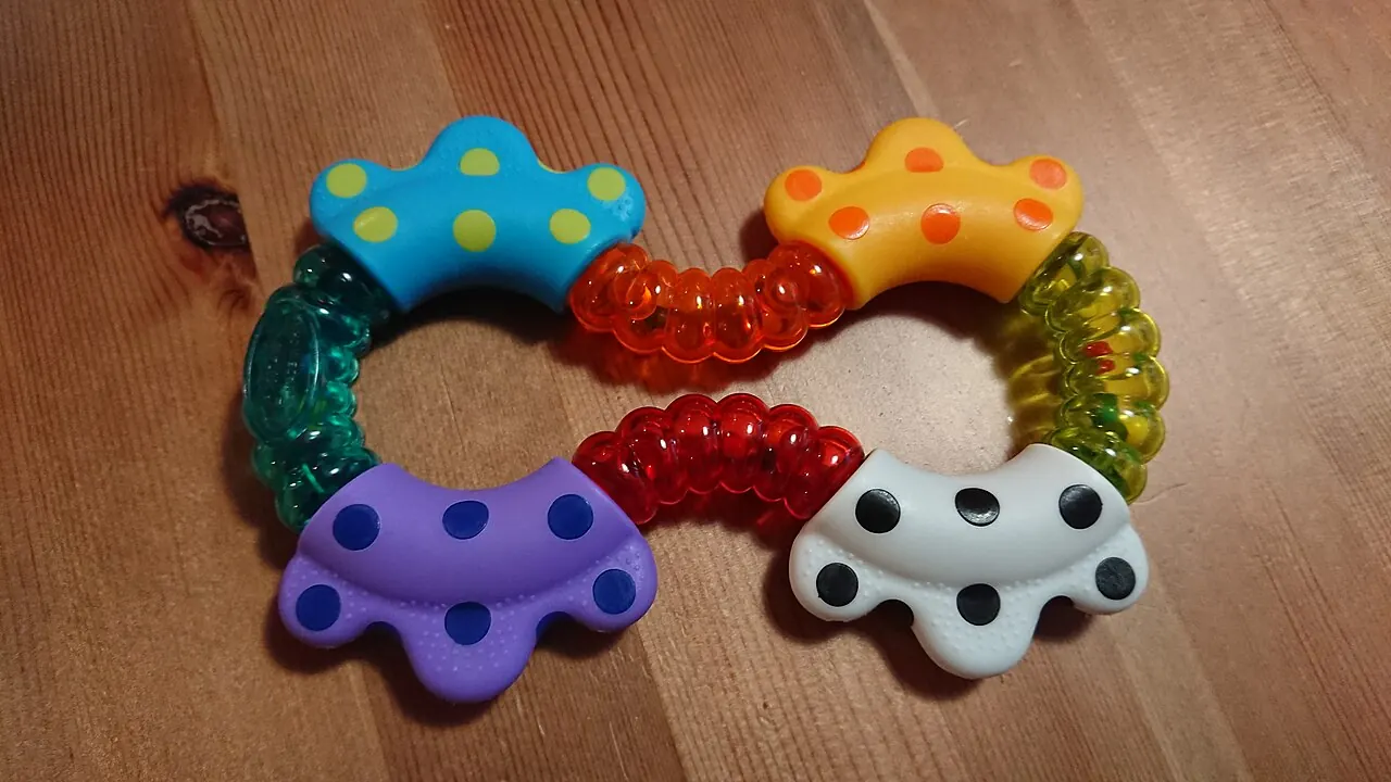 Colourful baby teething toys on a wooden floor