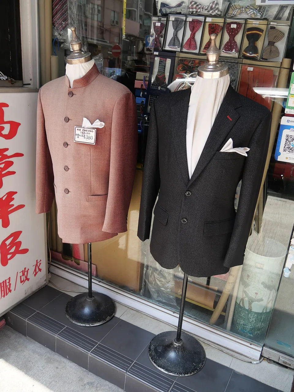 Two men's jackets on dress forms in a tailor's window