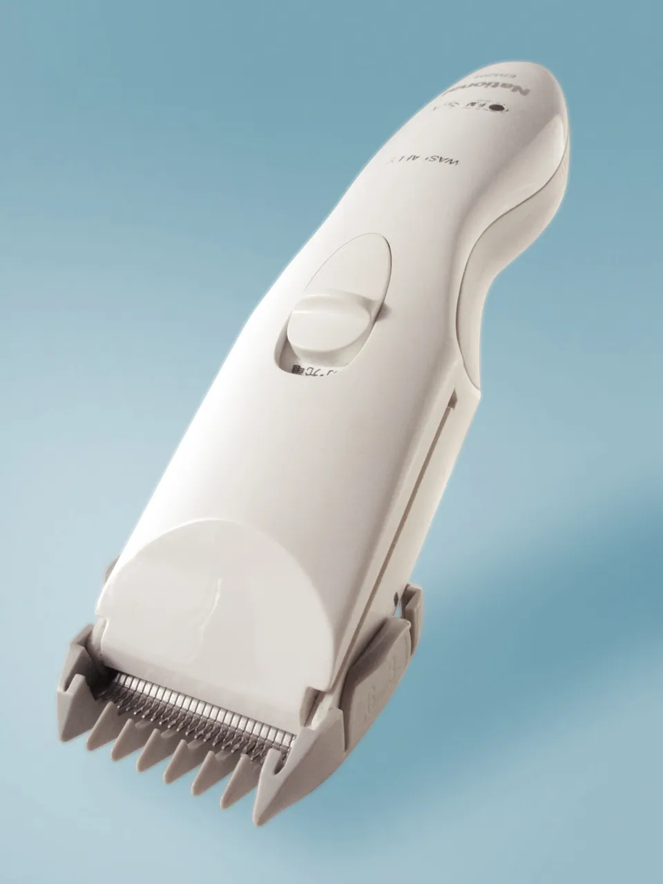 White electric hair clipper with a guard comb