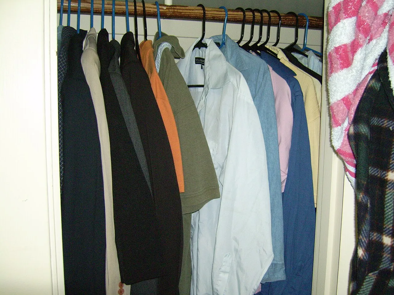 Wardrobe of shirts and jackets hanging in neutral colours