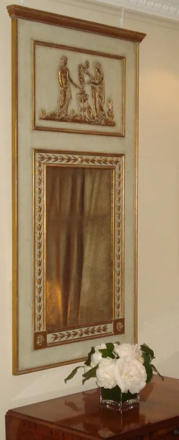 An antique framed mirror hanging on a wall