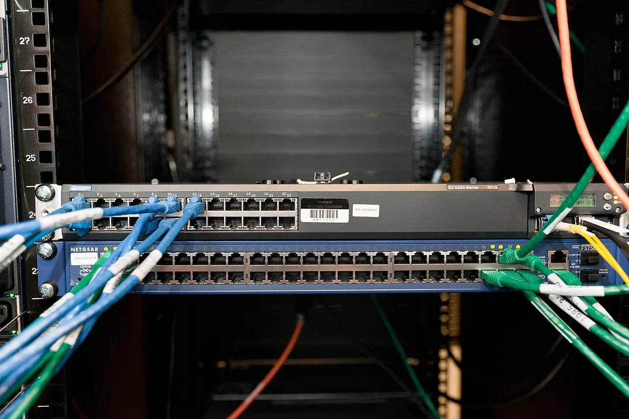 A network switch in a server rack with cables plugged in