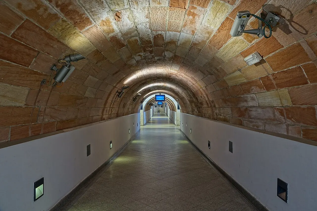Security cameras along the ceiling of a long tunnel