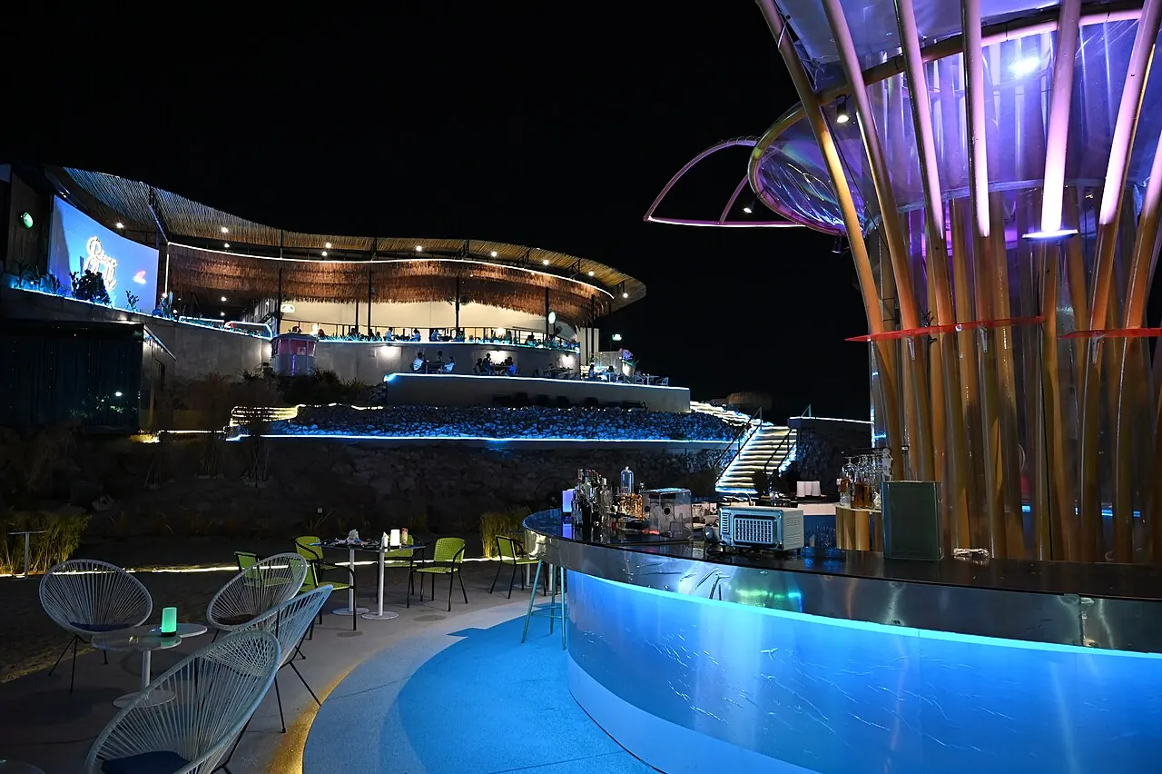 A modern building lit in blue at night