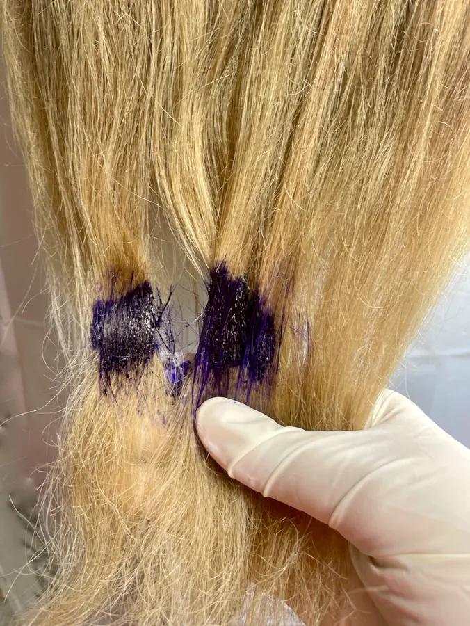 Blonde hair being coloured with purple dye