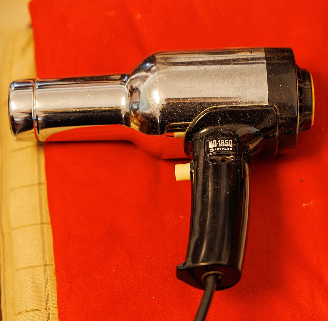 Vintage chrome hair dryer on a red background