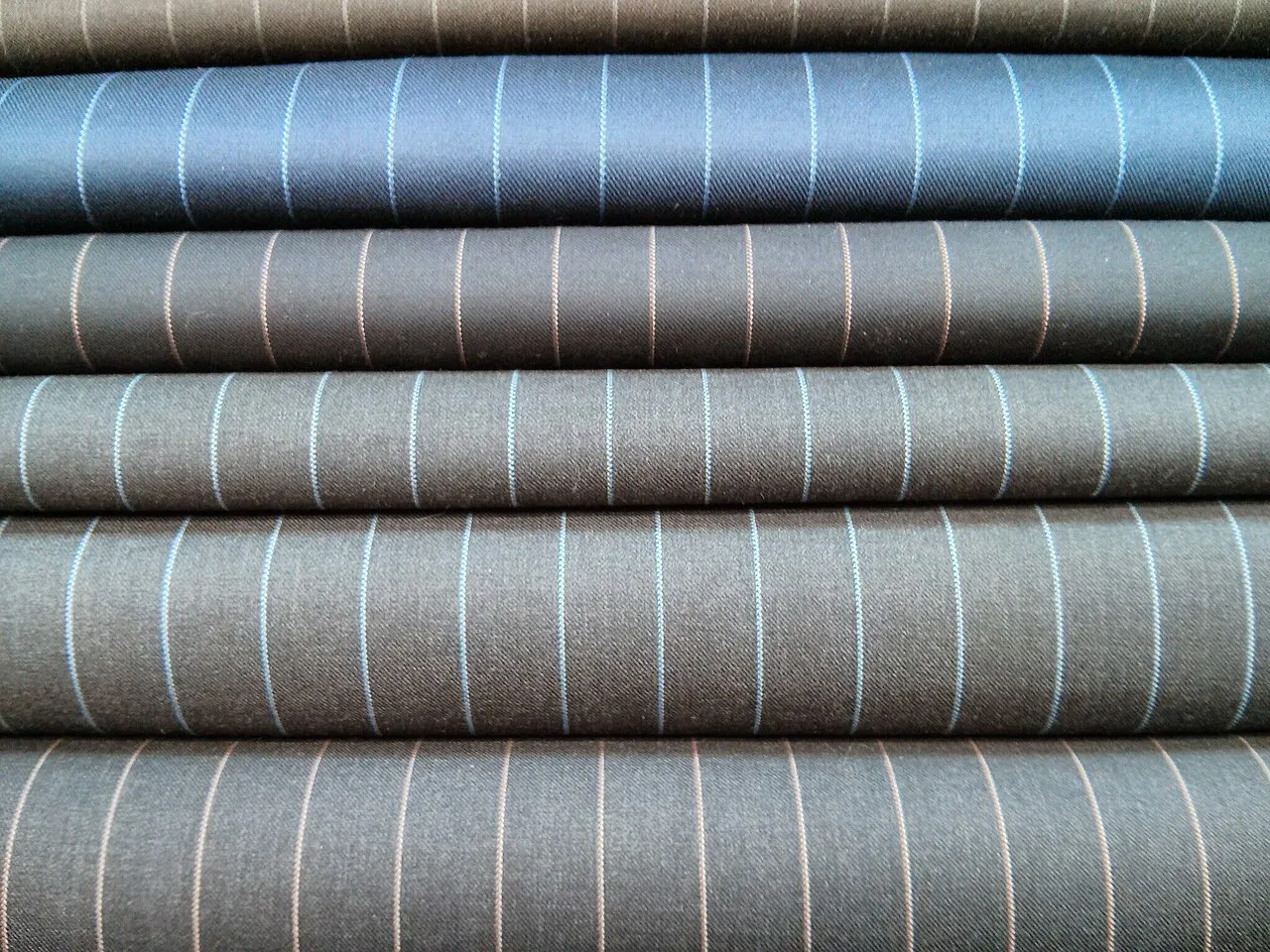 Stacked bolts of pinstripe suiting fabric