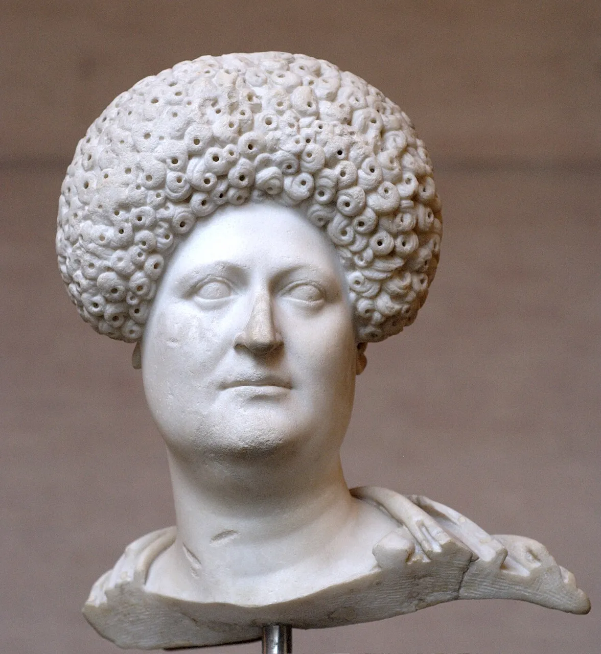 Roman marble bust of a woman with a round face and a high curled hairstyle