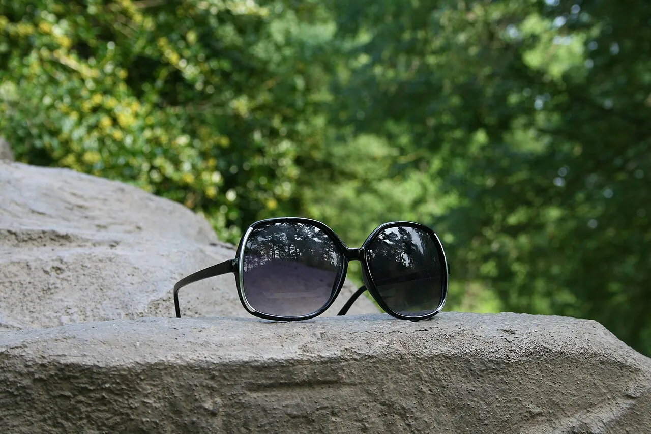 Sunglasses resting on a rock outdoors