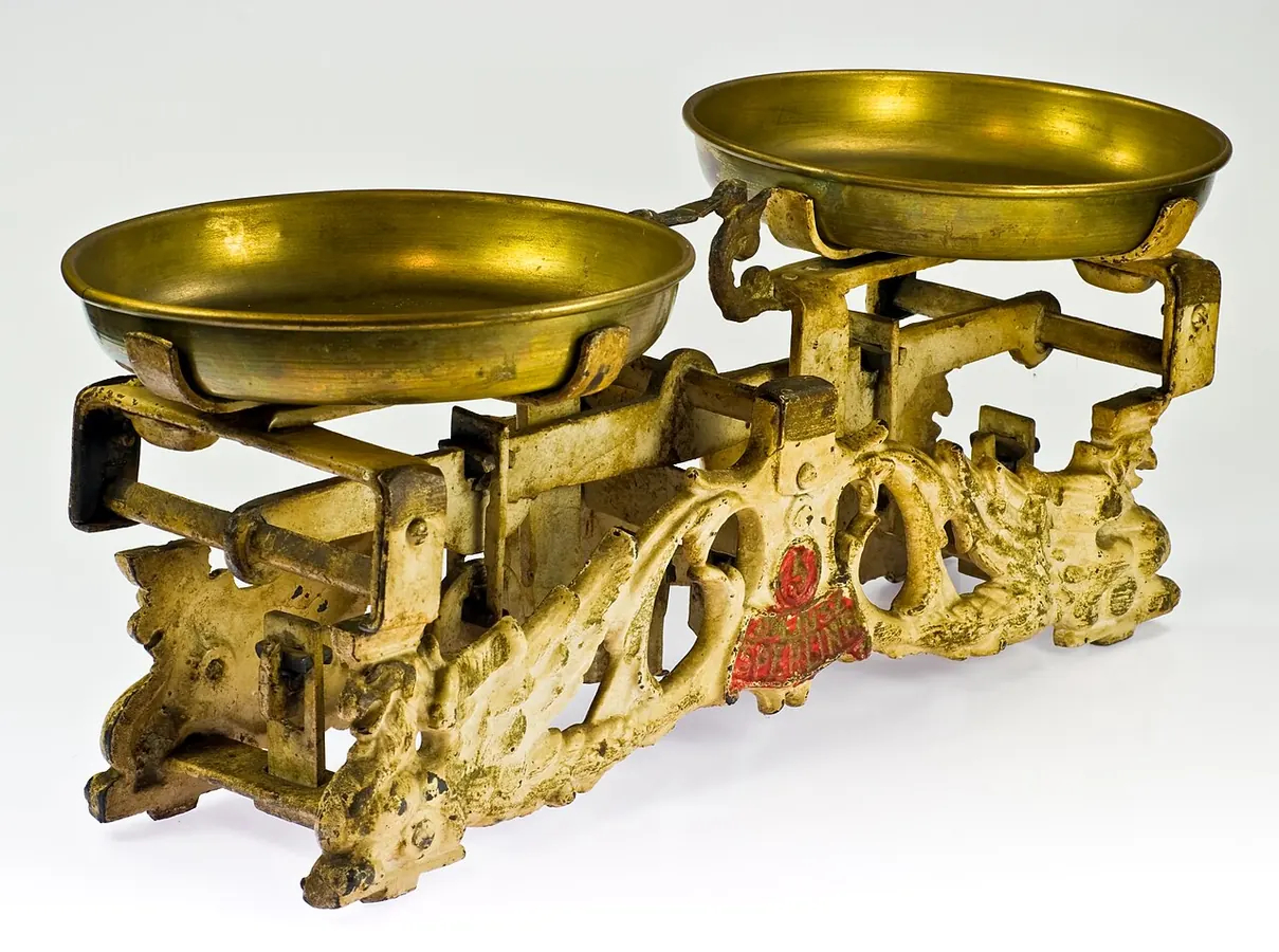 An ornate antique brass balance scale